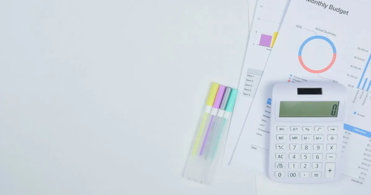 Schreibtisch mit Taschenrechner und Unterlagen für die Marketingbudget-Planung