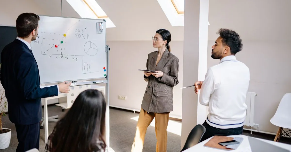 Team eines Mittelstandsunternehmens plant am Tisch die Marketingstrategie anhand von Charts