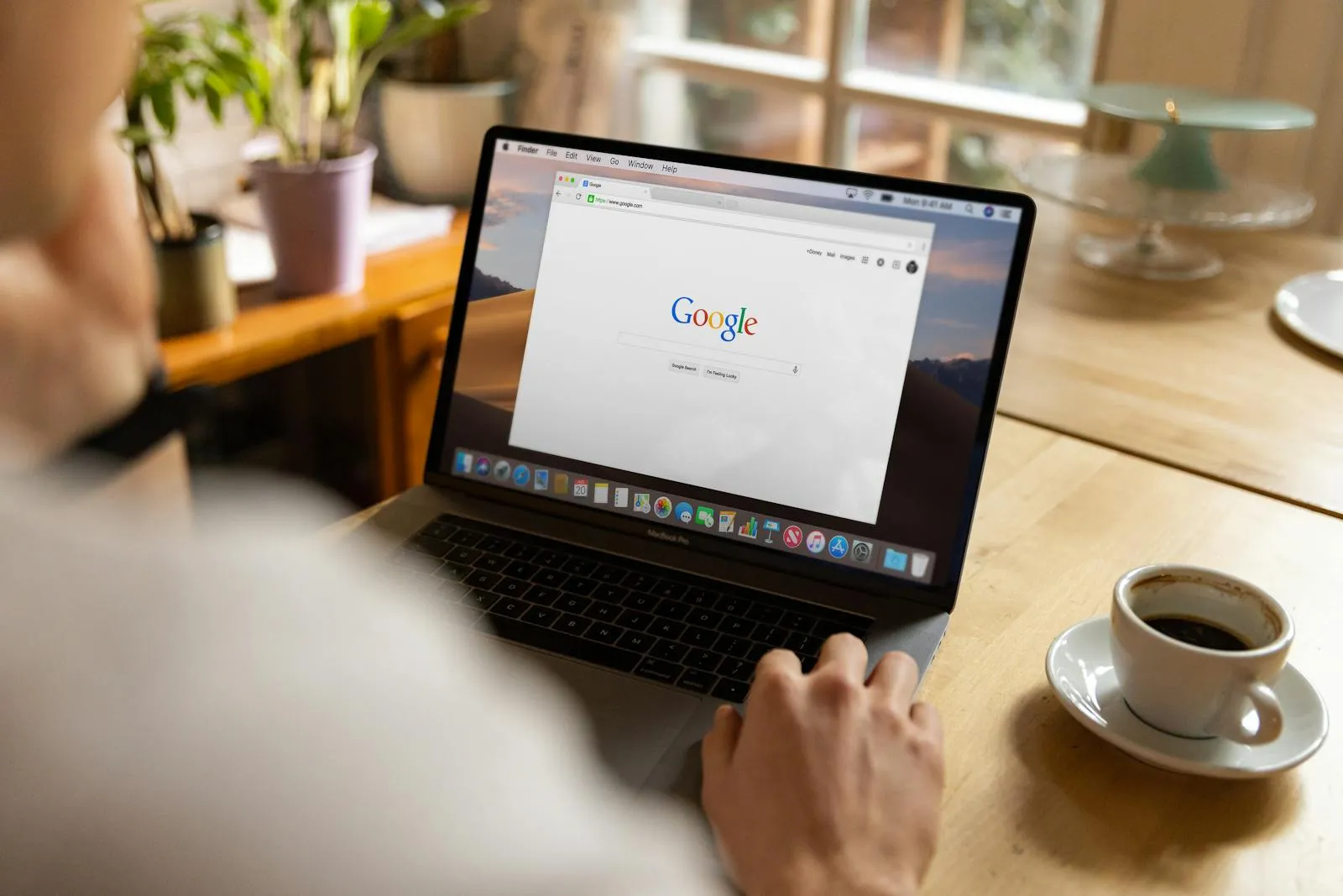 Person am Laptop bei der Google-Suche — SEO und Google Ads im Vergleich